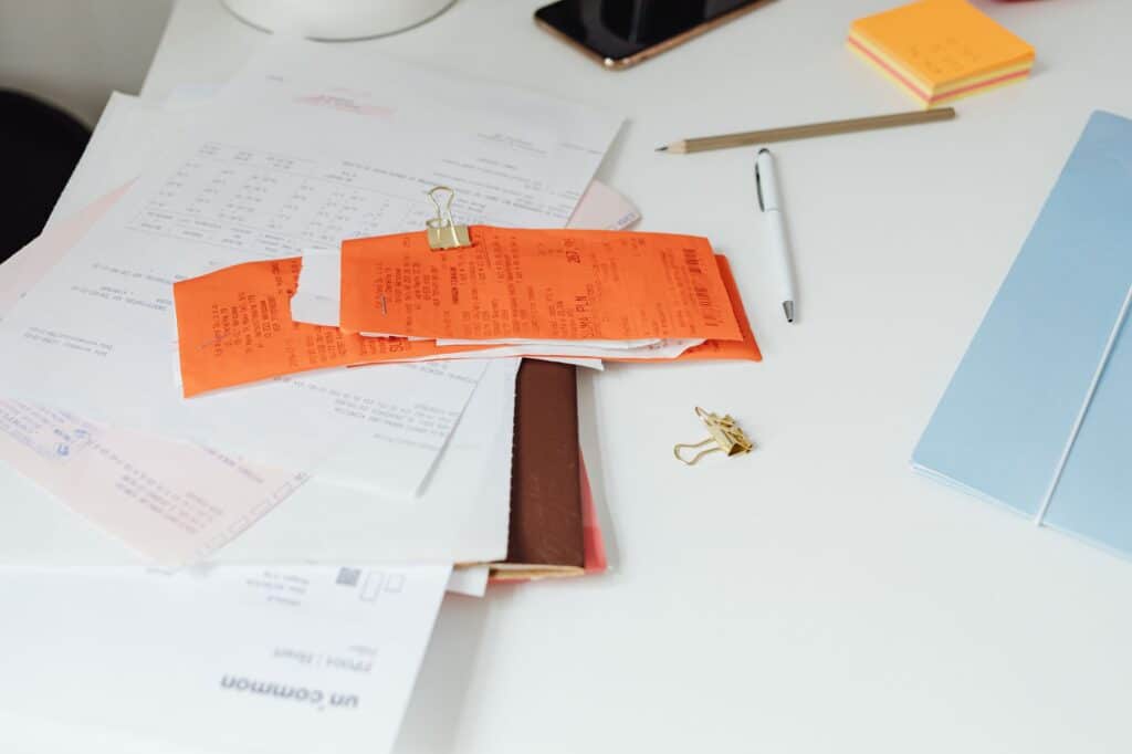 Receipts and business documents spread out on a white desk