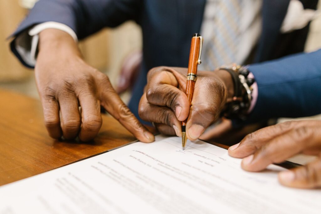 Close-up of hands signing a contract with a pen