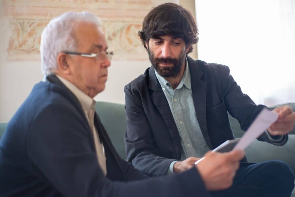 Man showing a document to an older client in a consultation